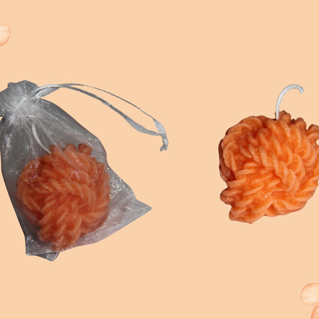 Velas artesanais em tom laranja suave, moldadas com um design único e delicado